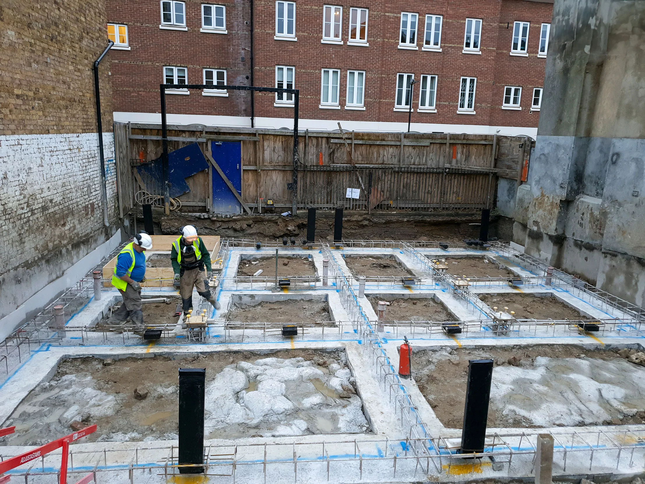 A couple of men standing on top of a construction site.