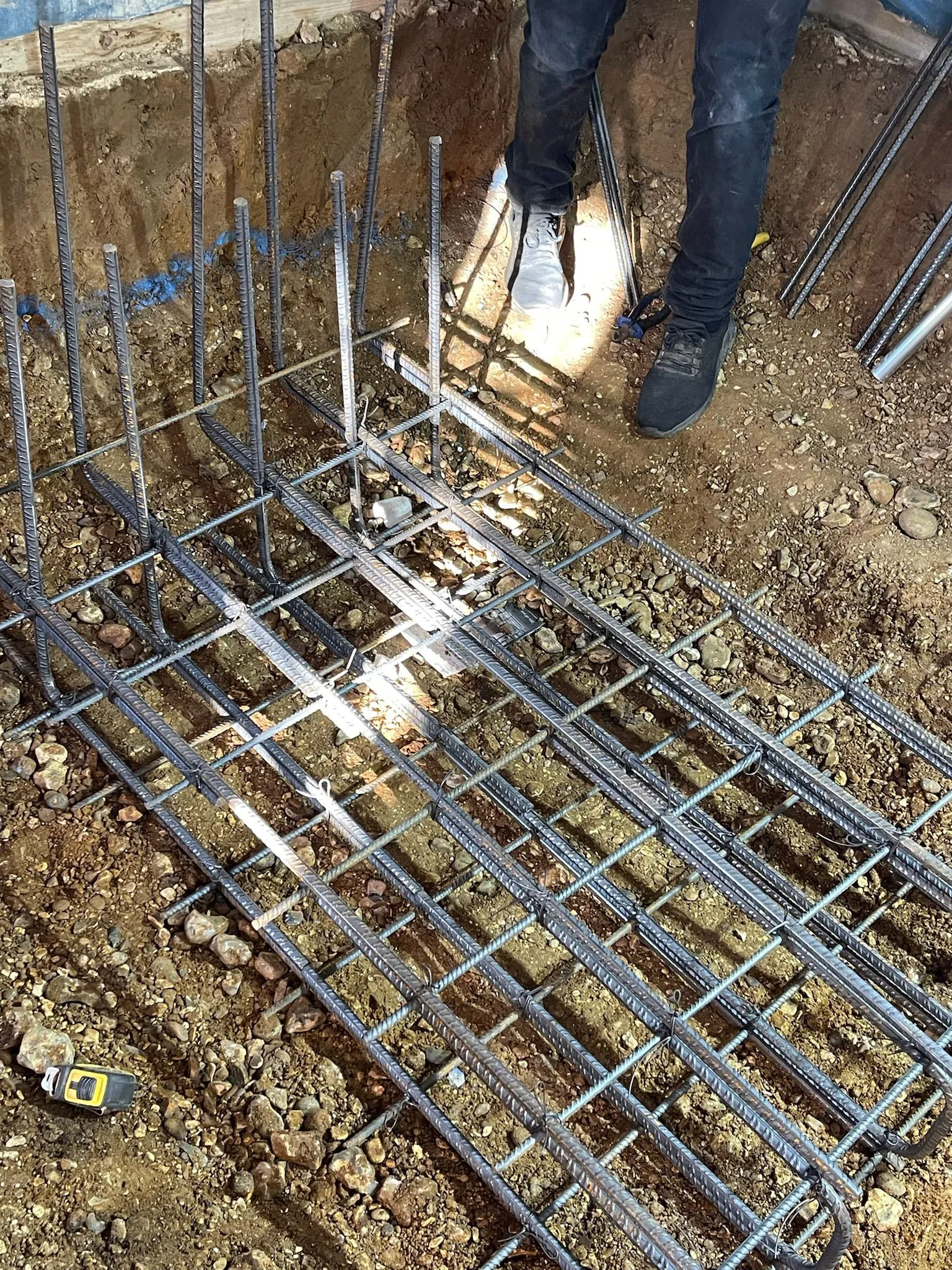A man standing on top of a pile of metal bars.