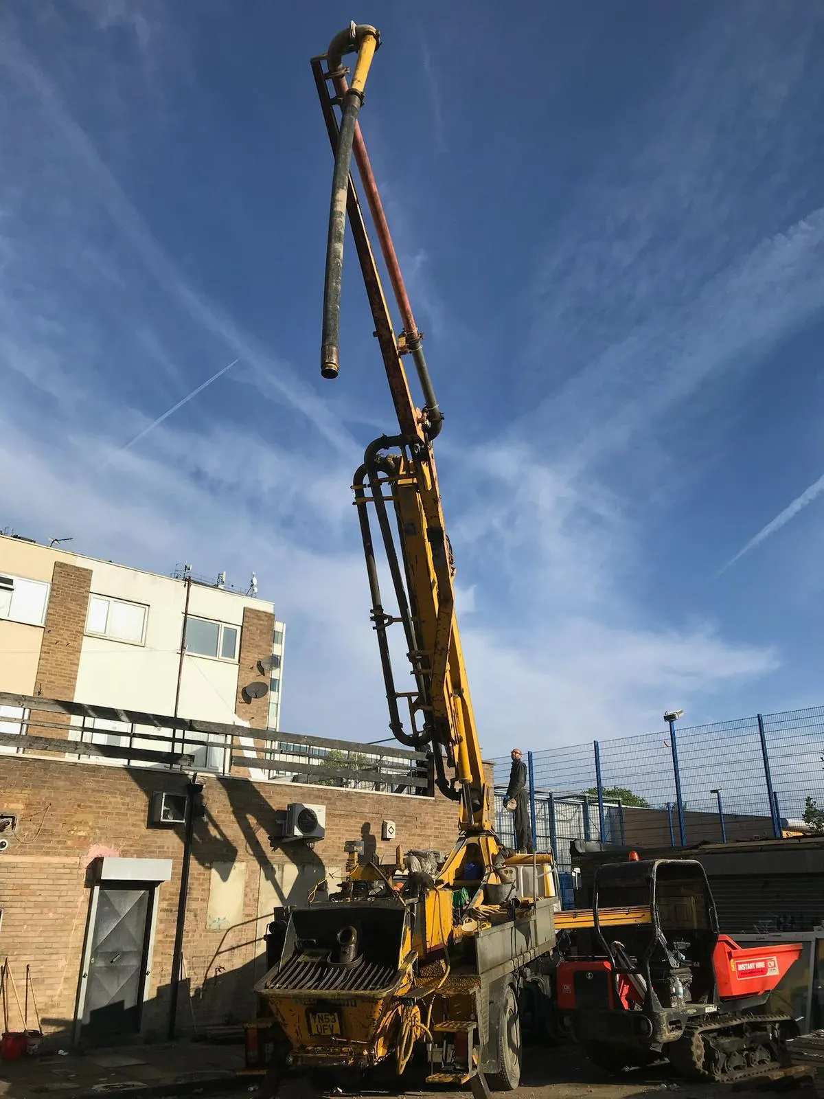 A man standing next to a truck with a crane on top of it.
